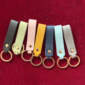Detail view of multi-colored faux leather keychains with elegant gold-tone metal rings.