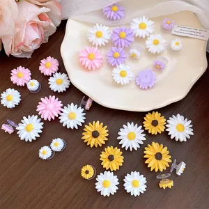 Detailed view of colorful resin daisy and sunflower charms for clog shoes.