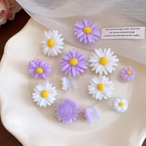 Close-up of white and purple resin daisy shoe charms on a wavy white plate