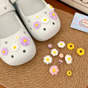 Close-up of cute resin flower shoe charms in various colors on a pair of clogs and mat