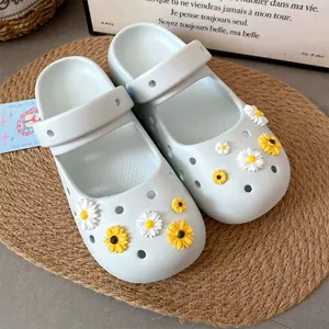 Close-up of cute white and yellow daisy resin charms on light blue clog shoes