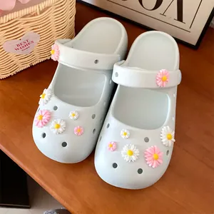 Detailed view of cute pink and white resin daisy charms on light blue clogs
