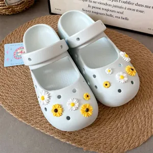 Detailed view of cute white and yellow daisy charms attached to light blue foam clogs