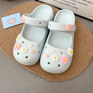 Detailed view of sweet resin daisy flower charms attached to light blue garden clogs