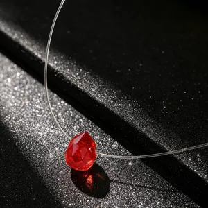 Detail van onzichtbare visdraad ketting met rode geslepen kristallen druppel hanger