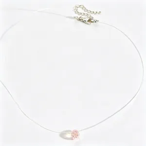Detailweergave van een onzichtbare vislijnketting met een roze facetgeslepen kristal