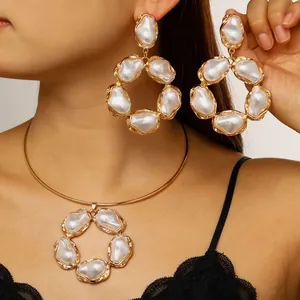Dettaglio di un set di orecchini e collana con perle barocche su una modella asiatica.