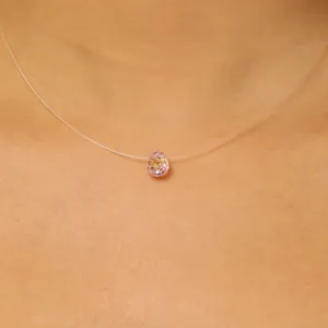 Gedetailleerde opname van transparante vislijnketting met een roze geslepen kristallen hanger