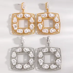 Dettaglio ravvicinato di orecchini quadrati vintage con perle barocche in oro e argento