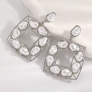 Dettaglio di orecchini quadrati in argento con perle barocche e montatura geometrica
