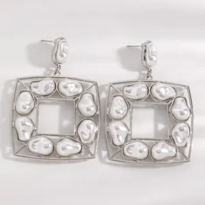 Primo piano di orecchini quadrati in argento con perle barocche vintage
