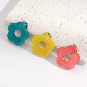 Detail view of colorful hollow flower pins in teal, yellow, and coral pink finishes