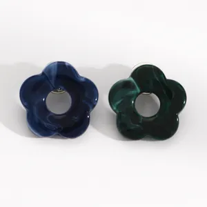 Detailed view of dark blue and green marbled hollow flower pins for glasses and suits