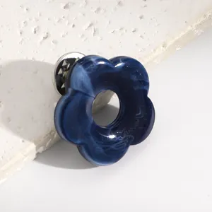 Detailed macro view of the blue marble resin texture on this hollow flower pin accessory.