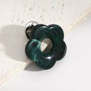 Close-up of a dark green marbled hollow flower brooch and glasses holder pin
