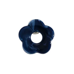 Close-up detail of navy blue marbled resin flower brooch and functional glasses holder