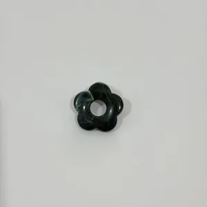 Detailed view of a dark green marbled hollow flower brooch and multifunctional glasses holder.