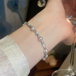 Elegante bracciale di perle e zirconi in stile francese indossato su un polso femminile dettaglio