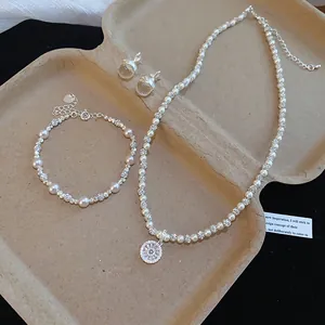 Dettaglio di elegante set di collana, bracciale e orecchini con perle e zirconi