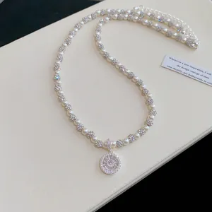 Dettaglio di una collana di perle in stile francese con ciondolo in zircone scintillante