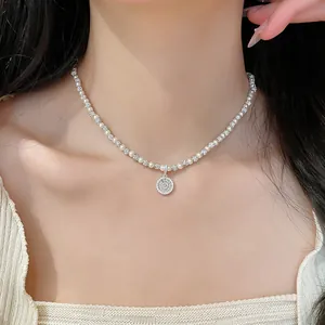 Dettaglio ravvicinato di una collana di perle con ciondolo in zircone in stile francese.