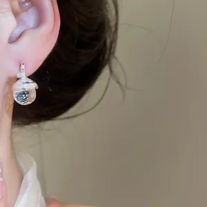 Elegante orecchino a forma di ghianda in argento con cristallo sfaccettato su modella