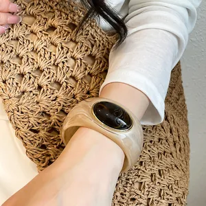 Close-up of a retro chunky acrylic bangle with an elegant oval black stone inlay.