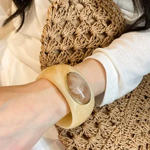Close-up view of a vintage acrylic chunky bangle with an oval marble pattern inlay