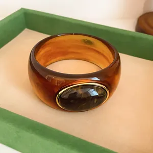 Detailed view of vintage amber acrylic wide bangle with marbled oval decorative stone