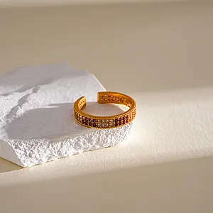 Nahaufnahme eines vergoldeten verstellbaren Rings mit lila und klaren Zirkonia.