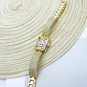 Detailed view of square gold watch with leopard print dial and rhinestone band