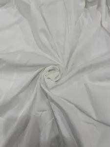 Macro view of elegant white dress fabric showing smooth texture and draping quality