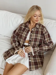 Close-up detail of retro loose plaid shirt featuring elegant lace cuffs and soft fabric texture.