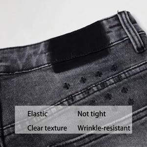 Texture détaillée d'un jean gris vintage avec de belles broderies de croix noires.