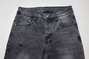 Gros plan sur un jean denim noir gris usé avec texture délavée vintage et déchirures