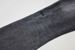 Gros plan du tissu denim noir gris délavé montrant la texture vintage.