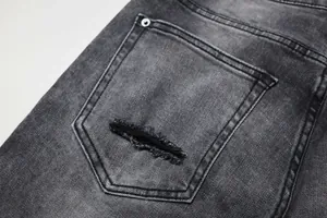 Gros plan sur le détail de la poche déchirée d'un jean en denim gris délavé pour homme