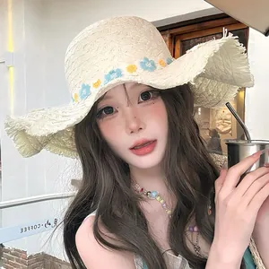 Elegant French style straw sun hat with lace brim and floral accents worn by a model