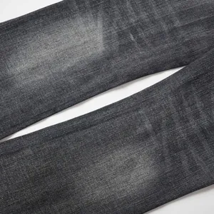 Close-up macro detail of washed black denim fabric texture with vintage faded finish