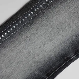 Macro detail view showing shiny rhinestone embellishments on dark grey high street denim jeans