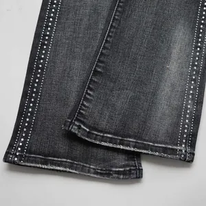 Close-up detail of rhinestone studs on grey high street flared denim jeans for men