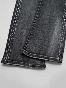 Detailed macro view of black denim flared jeans featuring side rhinestone stud stripes