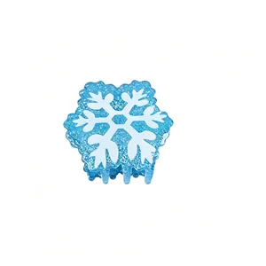 Close-up detail of a blue glitter snowflake hair claw clip with festive holiday design