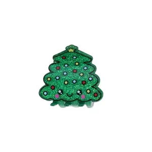 Detailed view of a cute green glittery Christmas tree hair claw clip with a kawaii face.