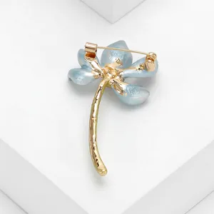 Detail back view of an elegant blue enamel lotus flower brooch in gold-tone alloy.