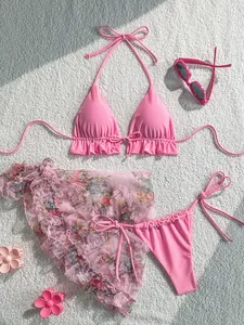 Detail view of pink three-piece bikini set featuring a floral mesh sarong and ruffle trim