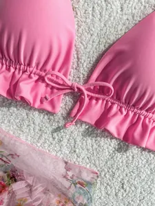Close-up of pink ruffle bikini top with front tie and floral mesh cover-up fabric