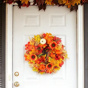 Autumn harvest wreath featuring pumpkins and maple leaves on a white door