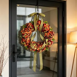 Decorative autumn hydrangea wreath with olive green ribbon hanging on a modern glass door