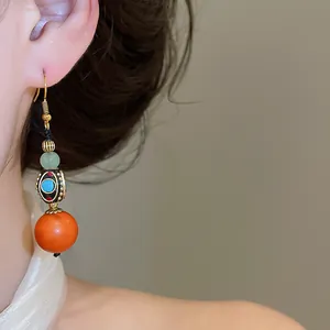 Close-up of vintage Neo-Chinese ethnic drop earrings with colorful resin beads on model